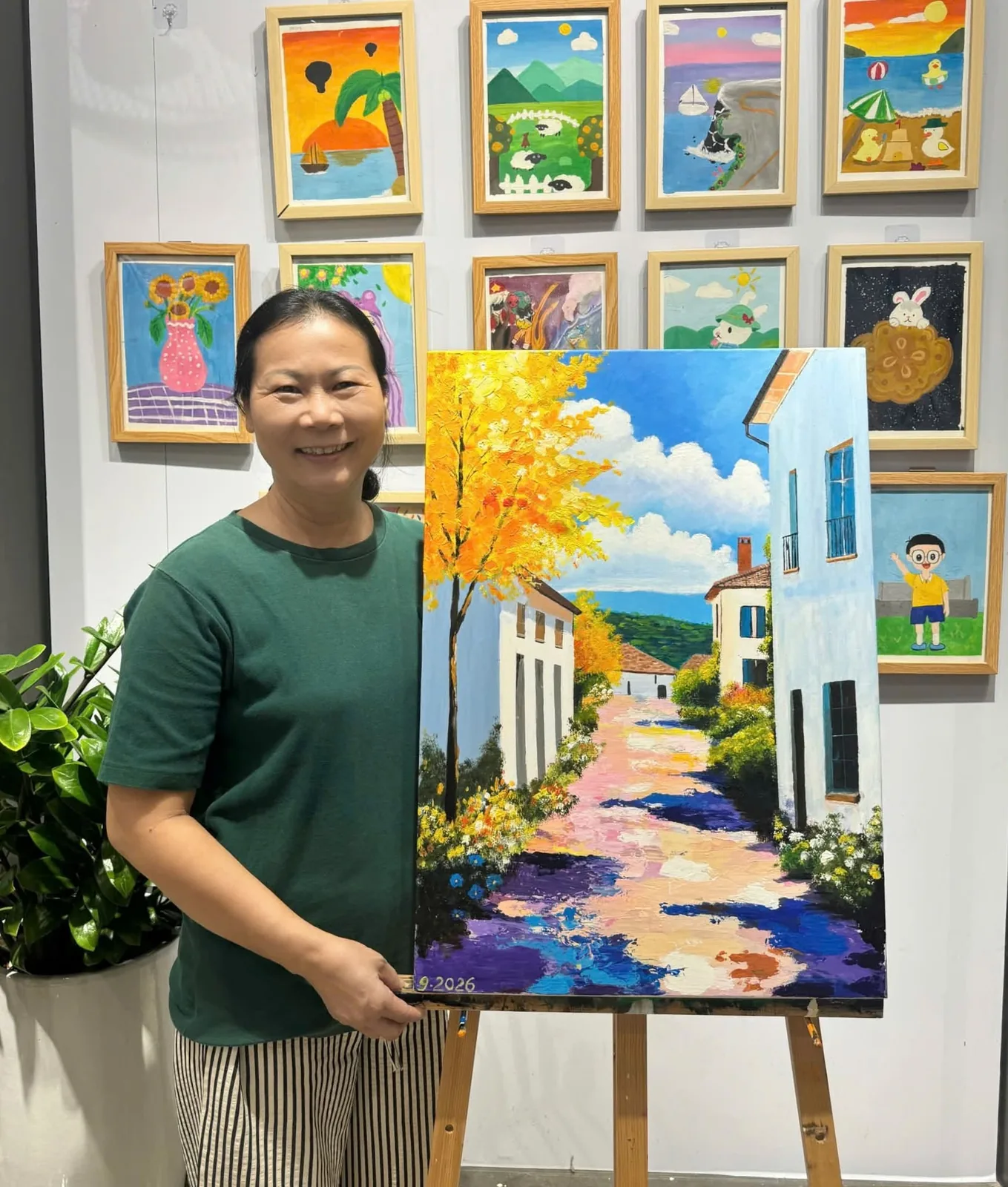 Học viên JoiArt Studio bên bức tranh acrylic con đường hàng cây vàng